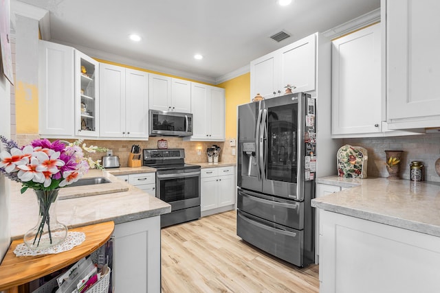 5404 E Pointe Villa Dr Unit 5406, Lighthouse Point, FL 33064 - kitchen with appliances with stainless steel finishes, crown molding, white cabinetry, recessed lighting, and decorative backsplash