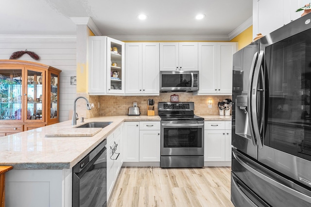 5404 E Pointe Villa Dr Unit 5406, Lighthouse Point, FL 33064 - kitchen featuring stainless steel appliances, crown molding, a peninsula, glass insert cabinets, and white cabinetry