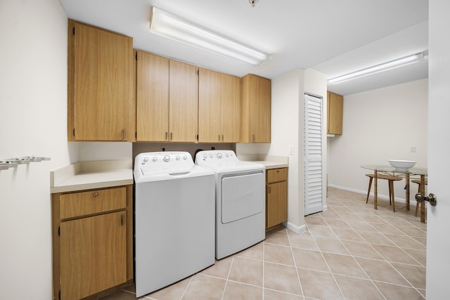 601 Seafarer Cir Unit 104, Jupiter, FL 33477 - laundry room featuring cabinet space, washing machine and clothes dryer, and light tile patterned floors