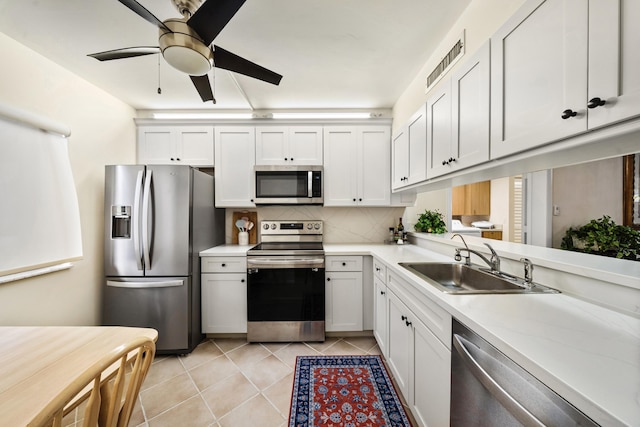 601 Seafarer Cir Unit 104, Jupiter, FL 33477 - kitchen with appliances with stainless steel finishes, light countertops, light tile patterned floors, ceiling fan, and white cabinets