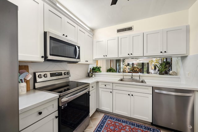 601 Seafarer Cir Unit 104, Jupiter, FL 33477 - kitchen featuring appliances with stainless steel finishes, light countertops, backsplash, and light tile patterned floors