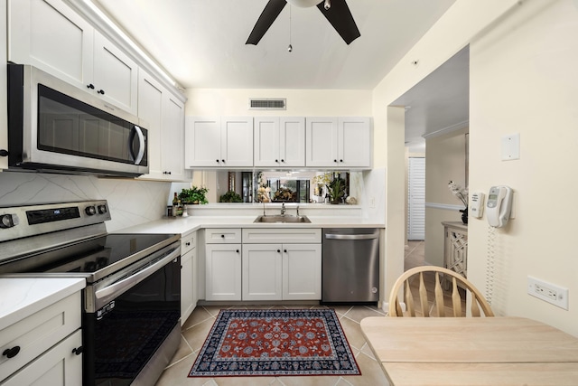 601 Seafarer Cir Unit 104, Jupiter, FL 33477 - kitchen featuring stainless steel appliances, light countertops, light tile patterned floors, a ceiling fan, and backsplash