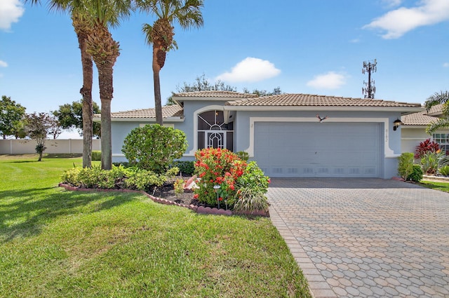 8182 Duomo Cir, Boynton Beach, FL 33472 - mediterranean / spanish-style house with stucco siding, a garage, a front lawn, decorative driveway, and a tiled roof
