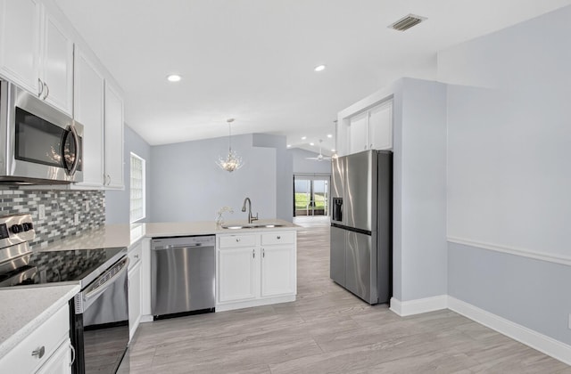 8182 Duomo Cir, Boynton Beach, FL 33472 - kitchen featuring appliances with stainless steel finishes, a peninsula, white cabinets, tasteful backsplash, and recessed lighting