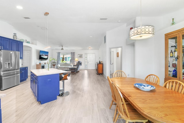 1037 SW Romaine Ln, Port Saint Lucie, FL 34953 - kitchen featuring stainless steel fridge with ice dispenser, blue cabinets, vaulted ceiling, a kitchen island, and a ceiling fan