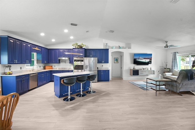 1037 SW Romaine Ln, Port Saint Lucie, FL 34953 - kitchen with appliances with stainless steel finishes, open floor plan, blue cabinetry, light countertops, and vaulted ceiling