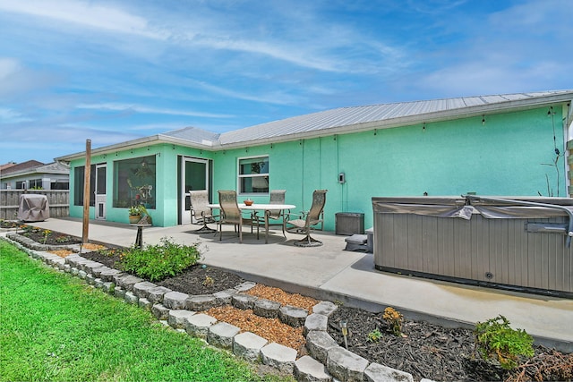 1037 SW Romaine Ln, Port Saint Lucie, FL 34953 - rear view of property with a hot tub, a patio area, stucco siding, and a metal roof