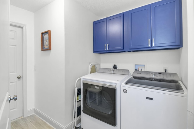 1037 SW Romaine Ln, Port Saint Lucie, FL 34953 - laundry area with washing machine and clothes dryer, cabinet space, light wood-style floors, and a textured ceiling