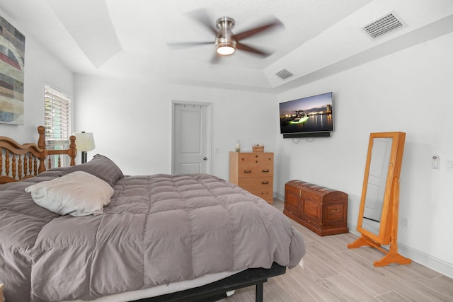 1037 SW Romaine Ln, Port Saint Lucie, FL 34953 - bedroom with a raised ceiling, light wood-type flooring, and a ceiling fan