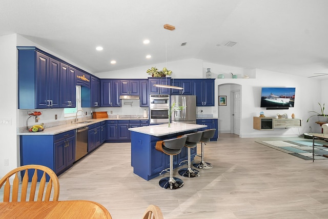 1037 SW Romaine Ln, Port Saint Lucie, FL 34953 - kitchen featuring appliances with stainless steel finishes, blue cabinets, vaulted ceiling, a breakfast bar, and a kitchen island