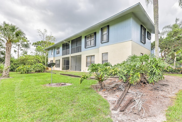 6545 SE Federal Hwy Unit 102, Stuart, FL 34997 - rear view of house with a lawn and stucco siding