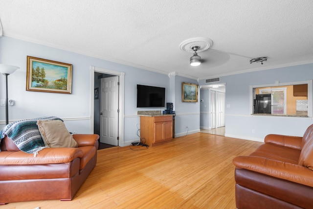 5961 NW 61st Ave Unit 203, Tamarac, FL 33319 - living room with a textured ceiling, crown molding, light wood-style flooring, and ceiling fan