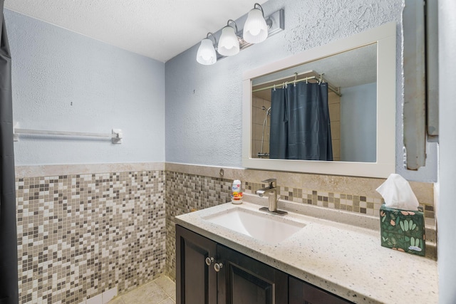 5961 NW 61st Ave Unit 203, Tamarac, FL 33319 - full bath featuring vanity, a textured wall, tile patterned floors, tile walls, and a shower with curtain