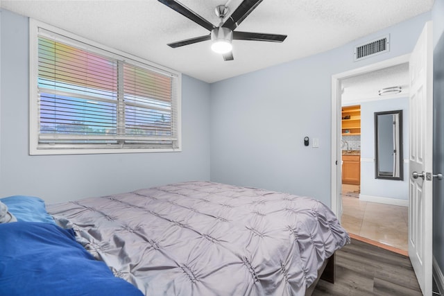 5961 NW 61st Ave Unit 203, Tamarac, FL 33319 - bedroom featuring wood finished floors, a textured ceiling, and a ceiling fan