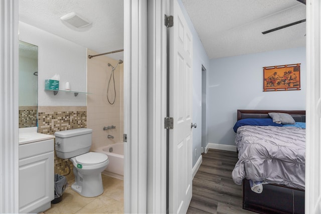 5961 NW 61st Ave Unit 203, Tamarac, FL 33319 - bedroom featuring a textured ceiling, ensuite bathroom, tile walls, and a ceiling fan