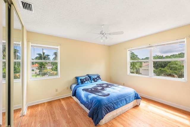 2322 SW Olympic Club Ter, Palm City, FL 34990 - bedroom with multiple windows, wood finished floors, a textured ceiling, and ceiling fan