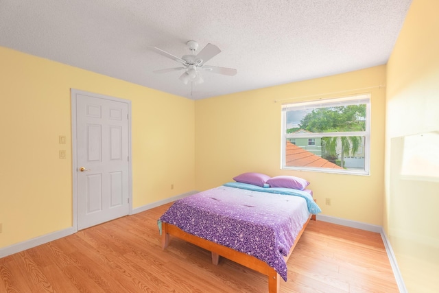 2322 SW Olympic Club Ter, Palm City, FL 34990 - bedroom with wood finished floors, a textured ceiling, and a ceiling fan