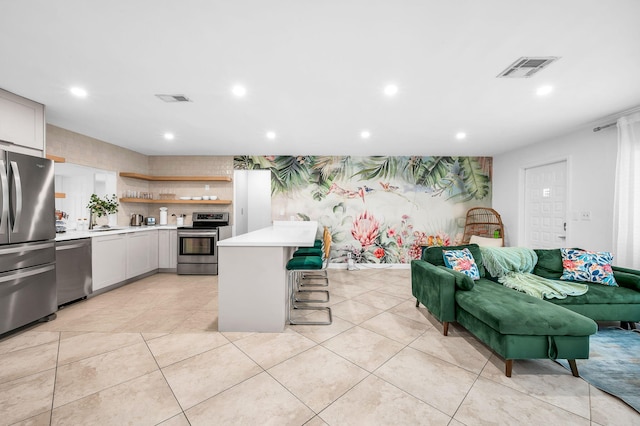 29 SE 8th Ave, Deerfield Beach, FL 33441 - kitchen featuring stainless steel appliances, recessed lighting, light countertops, open shelves, and a breakfast bar area