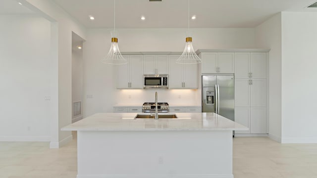 204 SE Via Sangro, Port Saint Lucie, FL 34952 - kitchen with appliances with stainless steel finishes, a center island with sink, light stone countertops, hanging light fixtures, and recessed lighting