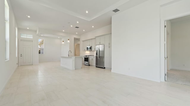 204 SE Via Sangro, Port Saint Lucie, FL 34952 - kitchen featuring appliances with stainless steel finishes, open floor plan, a center island with sink, light countertops, and recessed lighting