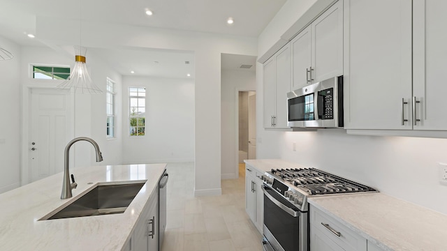204 SE Via Sangro, Port Saint Lucie, FL 34952 - kitchen featuring appliances with stainless steel finishes, light stone counters, pendant lighting, recessed lighting, and white cabinetry