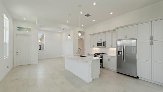 204 SE Via Sangro, Port Saint Lucie, FL 34952 - kitchen featuring appliances with stainless steel finishes, light countertops, an island with sink, decorative light fixtures, and recessed lighting