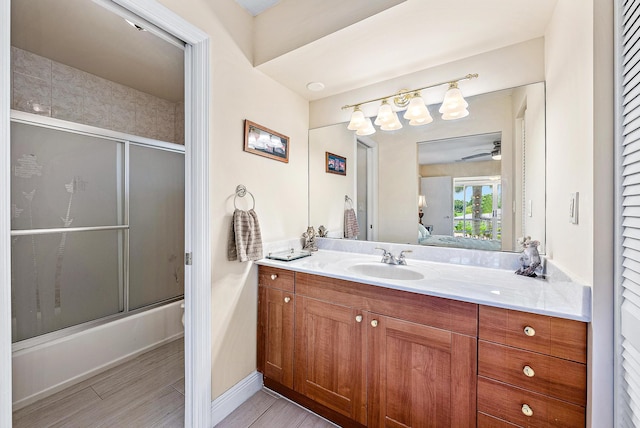 5560 Tamberlane Cir Unit 327, Palm Beach Gardens, FL 33418 - bathroom featuring vanity, bath / shower combo with glass door, ensuite bathroom, and wood finished floors