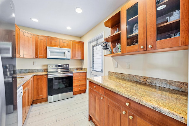 5560 Tamberlane Cir Unit 327, Palm Beach Gardens, FL 33418 - kitchen with stainless steel appliances, light stone counters, glass insert cabinets, brown cabinetry, and recessed lighting