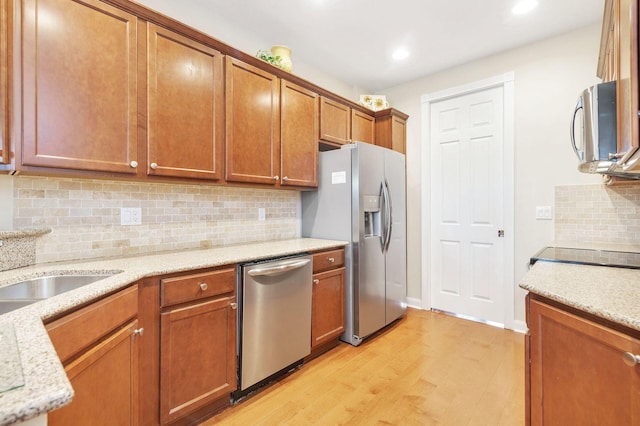3330 W Mallory Blvd, Jupiter, FL 33458 - kitchen with appliances with stainless steel finishes, light wood-style flooring, brown cabinets, backsplash, and recessed lighting