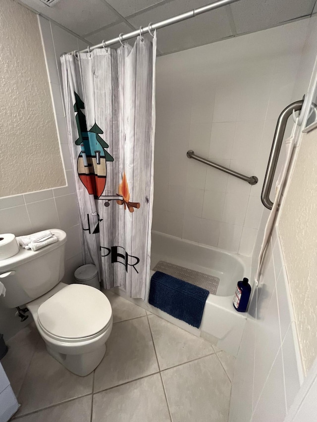 291 Saxony Unit G, Delray Beach, FL 33446 - full bathroom featuring tile walls, tile patterned floors, a textured wall, and shower / bathtub combination with curtain