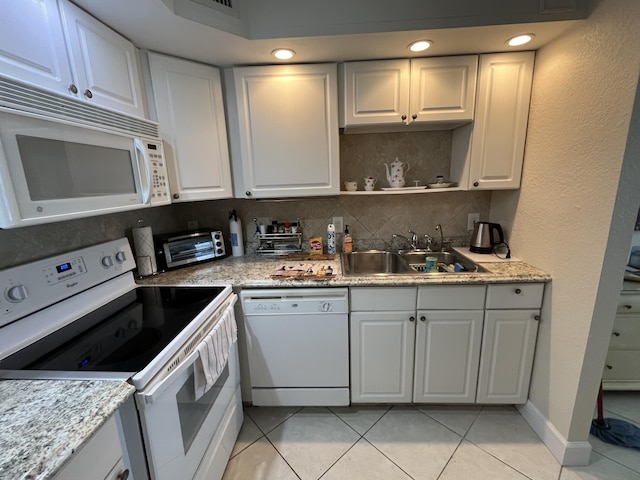 291 Saxony Unit G, Delray Beach, FL 33446 - kitchen with white appliances, decorative backsplash, light tile patterned floors, and white cabinets