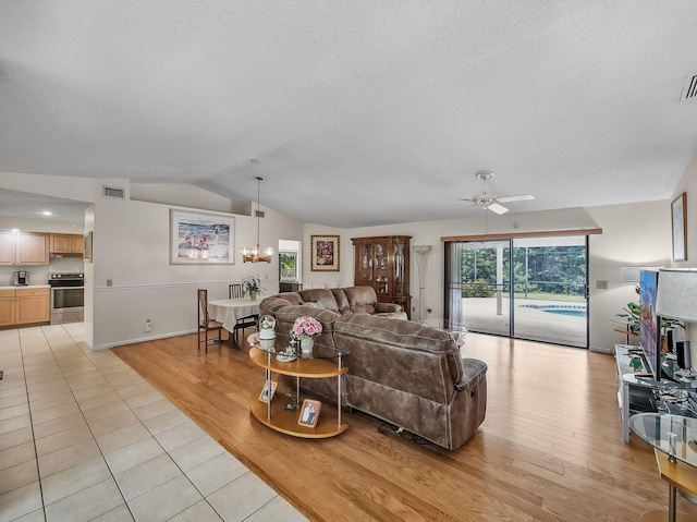 1680 SW Belgrave Ter, Stuart, FL 34997 - living room with lofted ceiling, a textured ceiling, light wood-style floors, ceiling fan, and a chandelier
