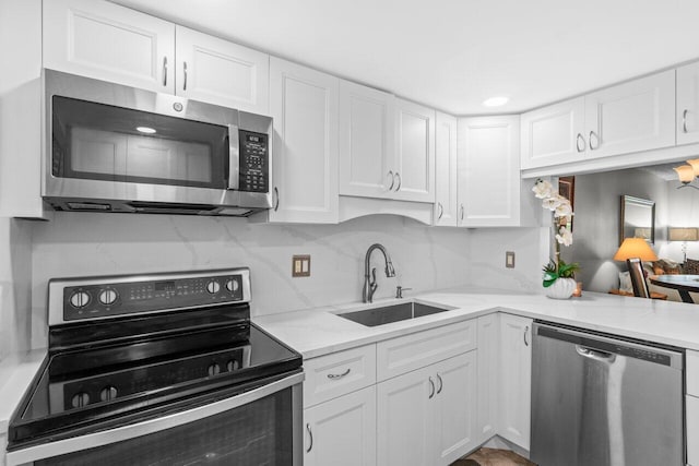 14721 Bonaire Blvd Unit 101, Delray Beach, FL 33446 - kitchen with stainless steel appliances, white cabinets, light stone counters, and tasteful backsplash