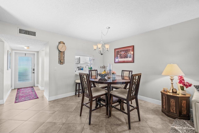 14721 Bonaire Blvd Unit 101, Delray Beach, FL 33446 - dining room featuring a chandelier, a textured ceiling, and light tile patterned flooring