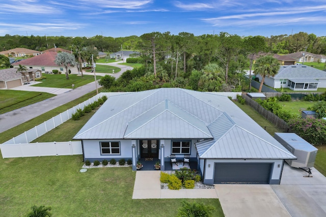 5476 NW Cambo Ct, Port Saint Lucie, FL 34986 - view of front of home featuring a fenced backyard, a garage, a metal roof, and concrete driveway
