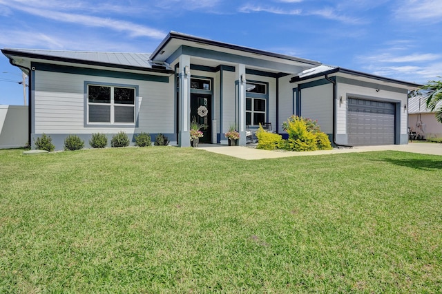 5476 NW Cambo Ct, Port Saint Lucie, FL 34986 - view of front of house with an attached garage, concrete driveway, a front lawn, and a metal roof