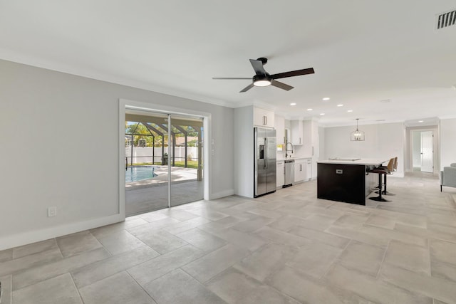 208 SW Langfield Ave, Port Saint Lucie, FL 34984 - kitchen with appliances with stainless steel finishes, a kitchen bar, light countertops, a ceiling fan, and white cabinetry