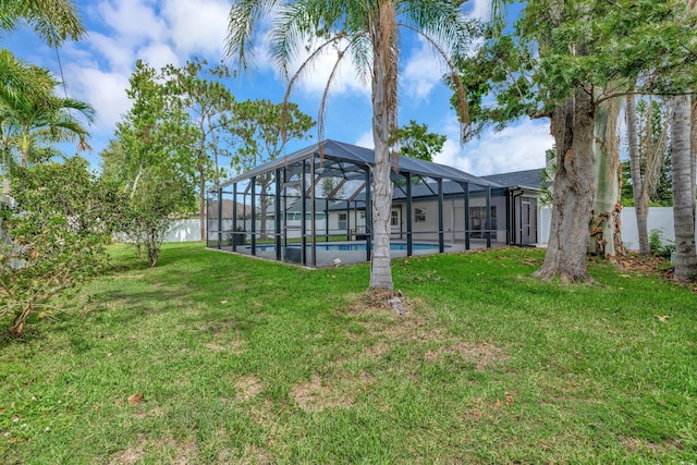 208 SW Langfield Ave, Port Saint Lucie, FL 34984 - rear view of property featuring an outdoor pool, a lawn, and glass enclosure