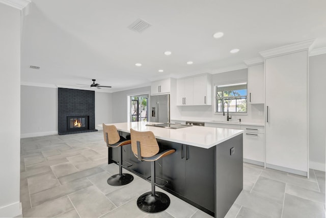 208 SW Langfield Ave, Port Saint Lucie, FL 34984 - kitchen with stainless steel fridge with ice dispenser, ornamental molding, white cabinets, healthy amount of natural light, and recessed lighting
