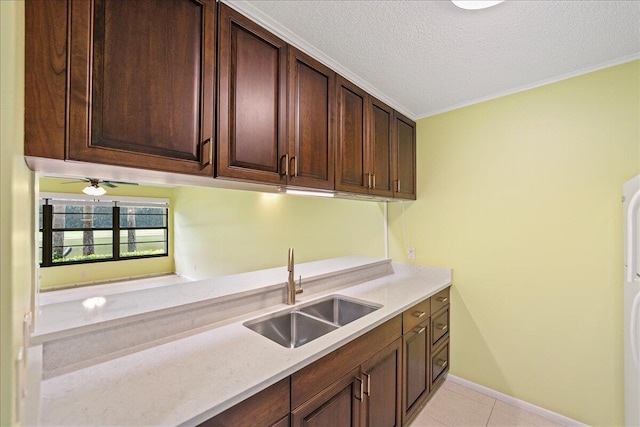 14 Plantation Dr Unit 105, Vero Beach, FL 32966 - kitchen with light tile patterned flooring, a textured ceiling, dark brown cabinetry, and ornamental molding