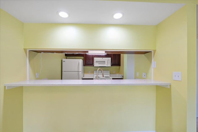 14 Plantation Dr Unit 105, Vero Beach, FL 32966 - kitchen with white appliances, a peninsula, light countertops, and recessed lighting