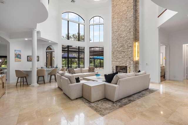 8984 Three Rail Dr, Boynton Beach, FL 33472 - living area with a high ceiling, ornamental molding, decorative columns, a fireplace, and marble finish floors