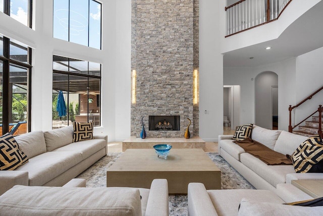8984 Three Rail Dr, Boynton Beach, FL 33472 - living room with a towering ceiling, healthy amount of natural light, a stone fireplace, arched walkways, and stairway