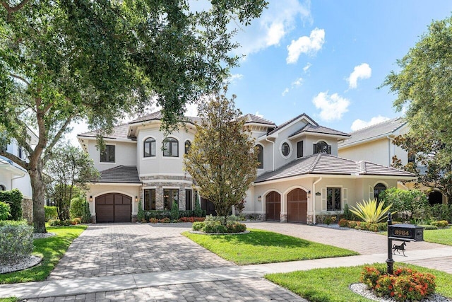 8984 Three Rail Dr, Boynton Beach, FL 33472 - mediterranean / spanish-style house featuring decorative driveway, stone siding, stucco siding, and a garage