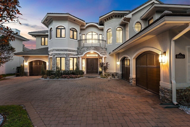 8984 Three Rail Dr, Boynton Beach, FL 33472 - view of front of house with a balcony, decorative driveway, stone siding, and stucco siding
