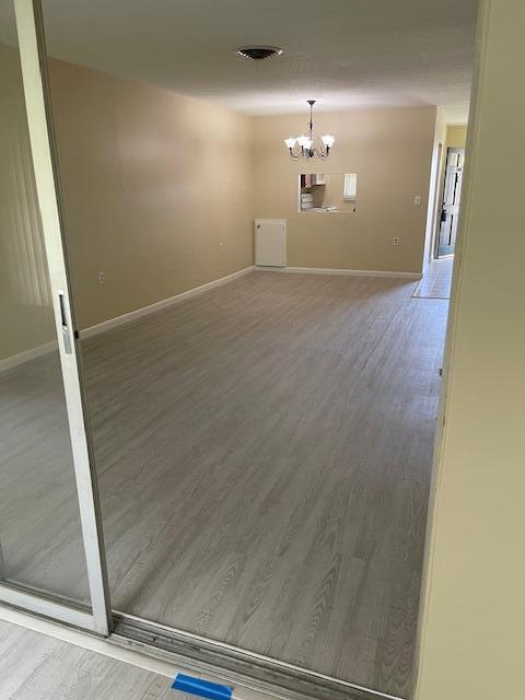 1900 S Kanner Hwy Unit 5-206, Stuart, FL 34994 - empty room featuring a chandelier and wood finished floors