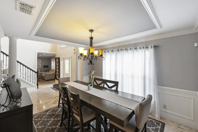 1571 SW Delos Ave, Port Saint Lucie, FL 34953 - dining room featuring a wainscoted wall, a chandelier, crown molding, stairs, and decorative columns