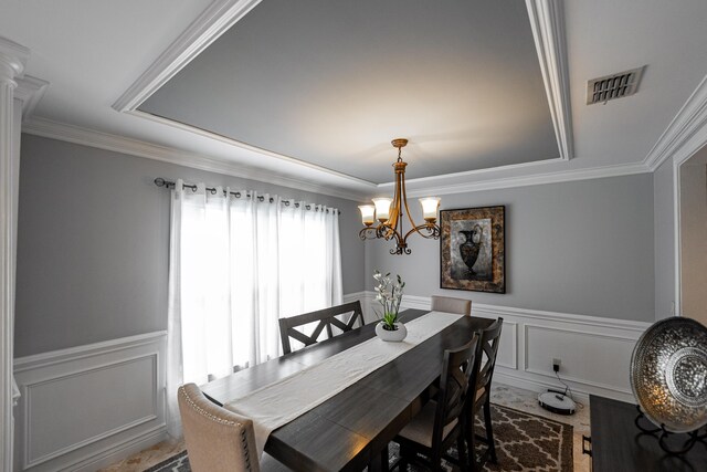 1571 SW Delos Ave, Port Saint Lucie, FL 34953 - dining room with a decorative wall, a raised ceiling, a chandelier, a wainscoted wall, and crown molding