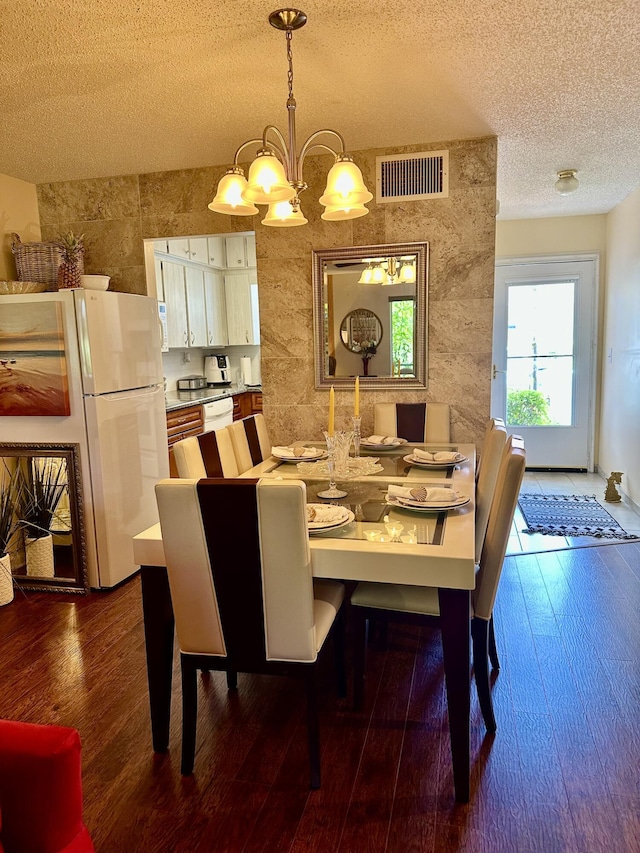 1957 SW Palm City Rd Unit B, Stuart, FL 34994 - dining area with a chandelier, a textured ceiling, and dark wood finished floors