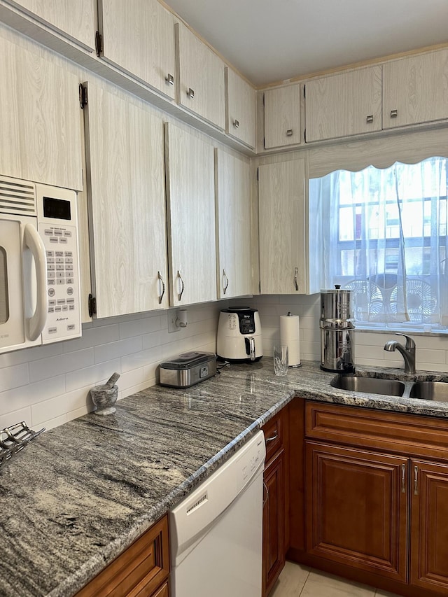 1957 SW Palm City Rd Unit B, Stuart, FL 34994 - kitchen featuring white appliances, backsplash, and dark stone counters